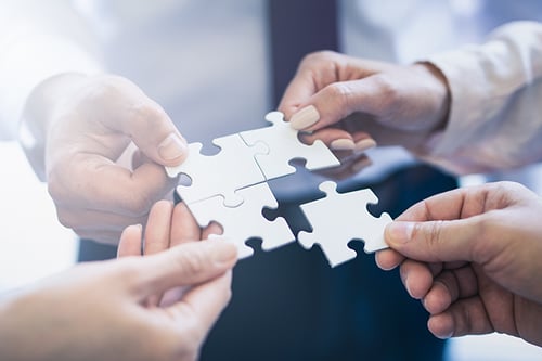A-group-of-business-people-assembling-jigsaw-puzzle